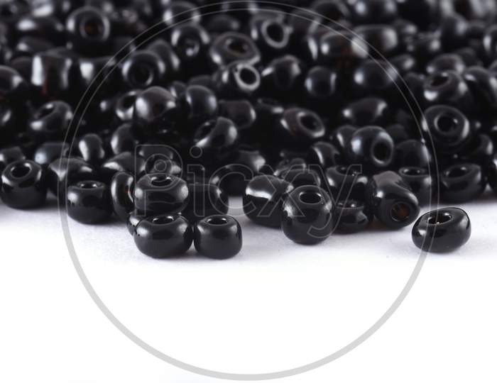Close Up Of Black Beads On The White Background. Background Or Texture Of Beads. Macro,It Is Used In Finishing Fashion Clothes. Make Bead Necklace Or String Of Beads For Woman Of Fashion.