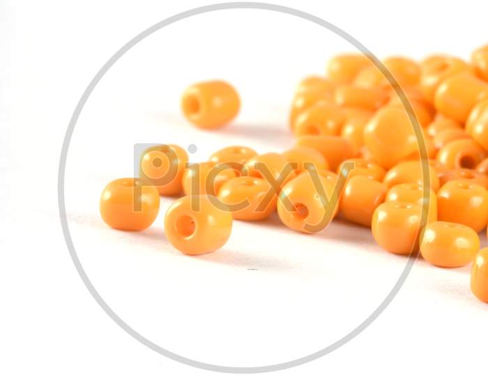 Close Up Of Yellow Beads On The White Background. Background Or Texture Of Beads. Macro,It Is Used In Finishing Fashion Clothes. Make Bead Necklace Or String Of Beads For Woman Of Fashion.