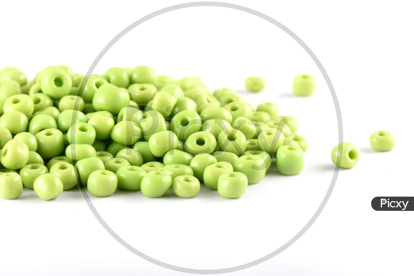 Close Up Of Light Green Beads On The White Background. Background Or Texture Of Beads. Macro,It Is Used In Finishing Fashion Clothes. Make Bead Necklace Or String Of Beads For Woman Of Fashion.