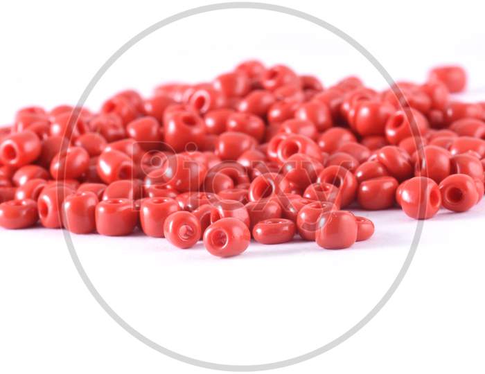 Close Up Of Red Beads On The White Background. Background Or Texture Of Beads. Macro,It Is Used In Finishing Fashion Clothes. Make Bead Necklace Or String Of Beads For Woman Of Fashion