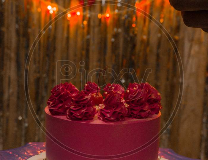 In The Front View Of Cake , In Background Lots Of Light And Decoration