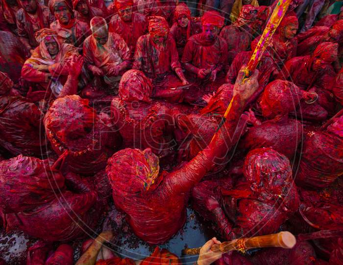 Indian people gathered in a temple and playing holi with colourful powder