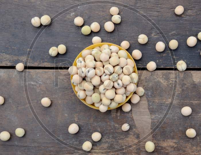 Closeup Bunch The Ripe Yellow Brown Peas Beans In The Plastic Bowl Over Out Of Focus Wooden Brown Background.