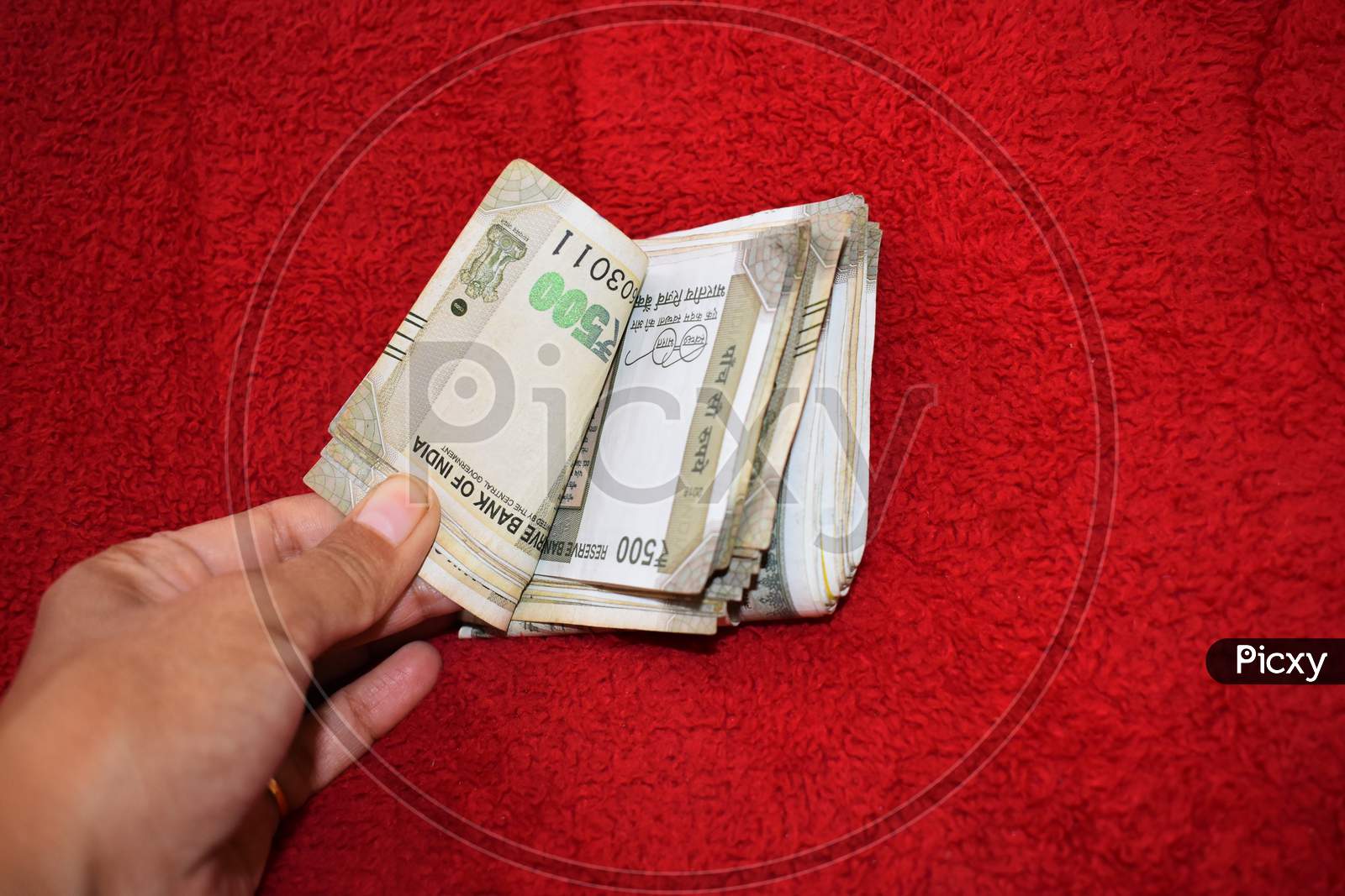 500 Indian Currency In Hand Red Background