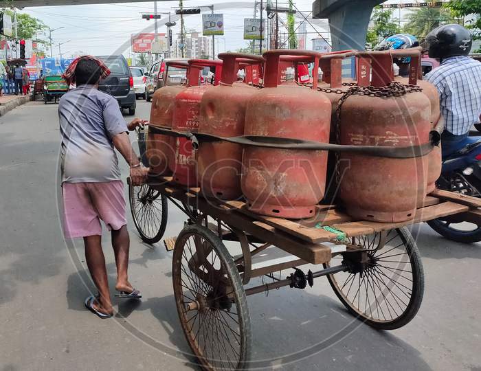 Lpg Or Liquid Petroleum Gas Cylinder Delivery Man Pulling His Van With Gas Cylinders For Delivery