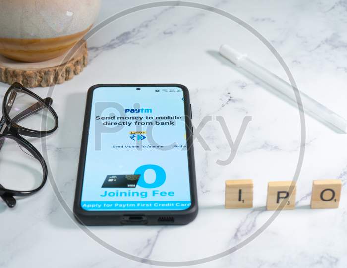 Paytm Logo Screen On Mobile Phone With Pen And Spectacles Placed Nearby Showing The Ipo Of The Indian Startup Unicorn Decacorn Payment Services Provider For Cashless Payment