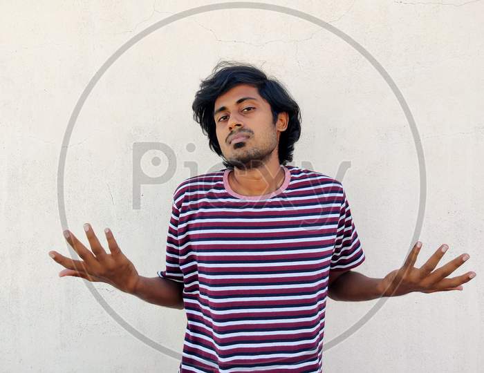 Clueless South Indian Tamil Man Shrugging Shoulders Wearing Stripes Tshirt. Confused. I Don'T Know. White Background