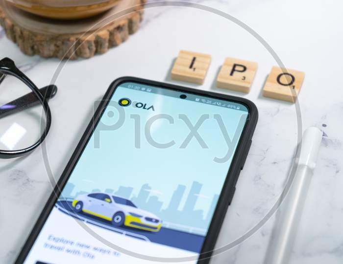 Mobile Phone With The Ola Taxi Hailing App Competing With Uber For Ride Sharing, Taxi Auto Cross City Cabs Haling Unicorn With Ipo Coming Up