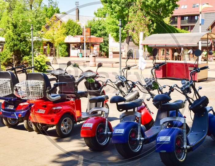 Palanga, Lithuania -14Th June, 2021: Many Colorful Fat Tyre Electric Scooters Parked For Rent In Public Famous Lithuania Sea Resort.