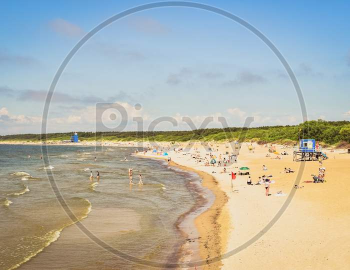 People Enjoying Sunny Summer Day On The Beach In Lithuania Famous Resort Palanga