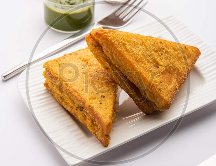 Sandwich Bread Pakora Or Triangle Shape Pakoda Served With Tomato Ketchup, Green Chutney, Popular Indian Tea-Time Snack