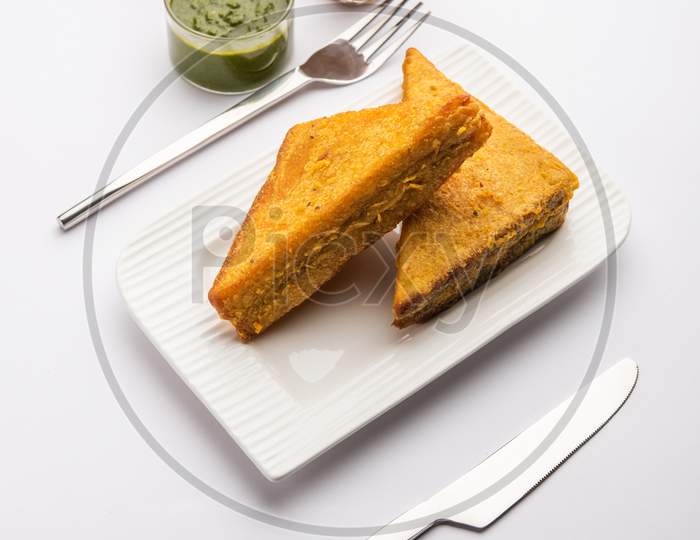 Sandwich Bread Pakora Or Triangle Shape Pakoda Served With Tomato Ketchup, Green Chutney, Popular Indian Tea-Time Snack