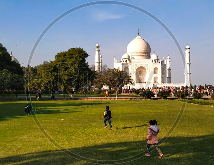 Kids playing  in the garden of the Taj Mahal