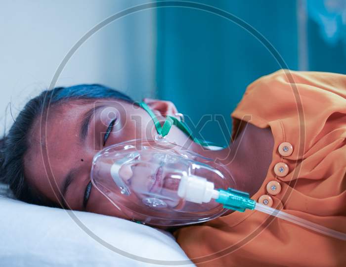 Little Girl Kid Breathing On Ventilator Oxygen Mask Due To Coronavirus Covid-19 Breathing Shortness Or Dyspnea Infection - Concept Of Children Healthcare And Medical During Third Wave Pandemic Outbreak