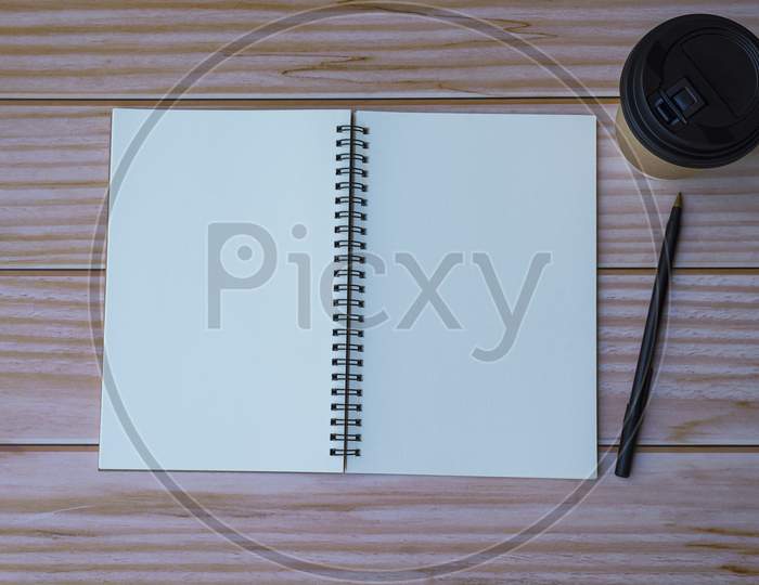 Note Book With Pen And Coffee On Wooden Table. Flat Lay, Top View