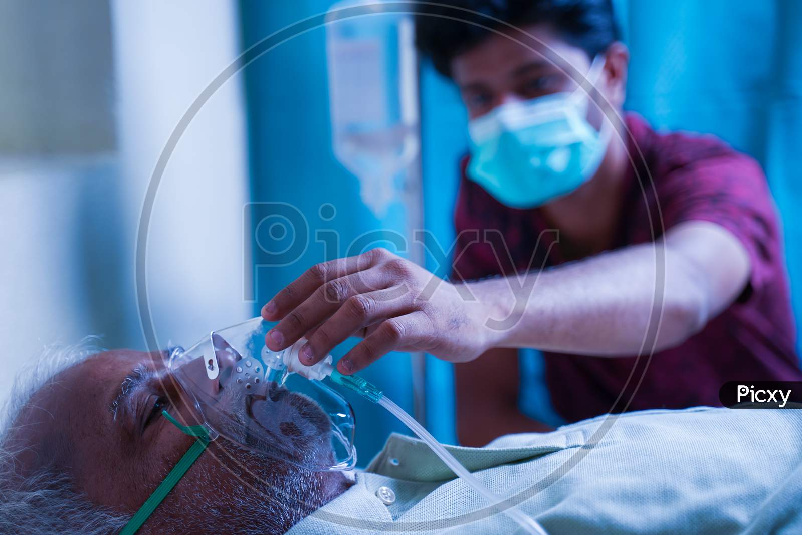 Son With Medical Face Mask Taking Care Of Sick Old Father At Hospital By Checking Ventilator Oxygen Mask - Concept Of Senior People Parental Health Care And Medical.