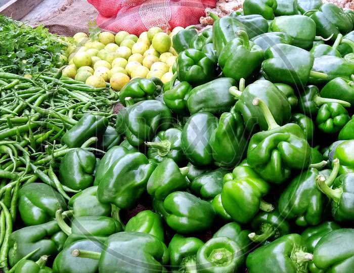 Assortment Of Fresh Vegetables. Capsicum (Shimla Mirchi), Lemon, Spicy Green Chilly, Coriander