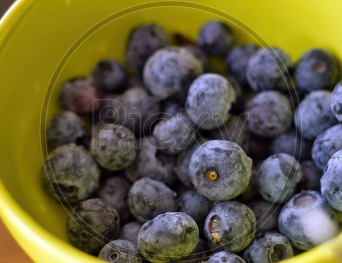 Top View Closeup Of Fresh Blueberries In A Bowl. Blue Forest Berries. Macro Photography Of Healthy Fruits.