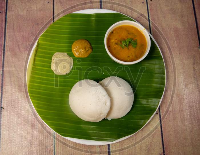 Top View Of Delicious Indian Idly With Chutney And Sambar On Banana Leaf