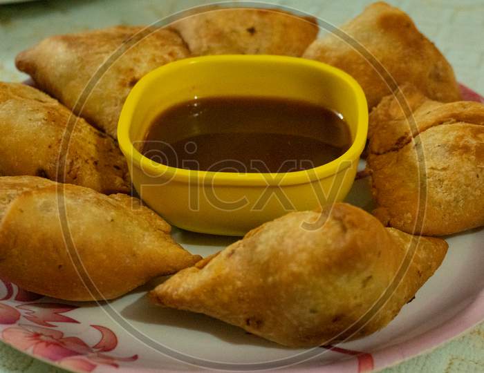 This is an Indian dish called samosa which is served on a white plate with sauce