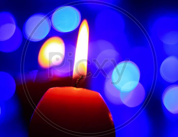 Candle lights in darkness with colorful light effects and bokeh for solemn moments and wallpaper. Candle flame light at night with background.