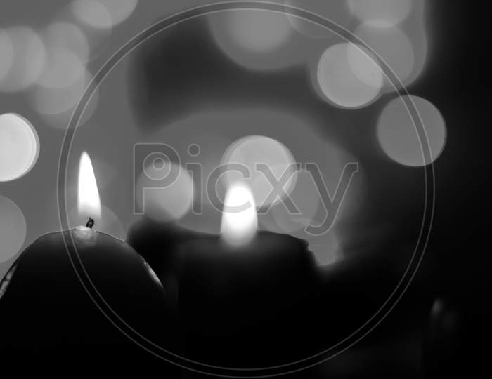 Candle lights in darkness with light effects and bokeh for solemn moments and wallpaper. Candle flame light at night with background.