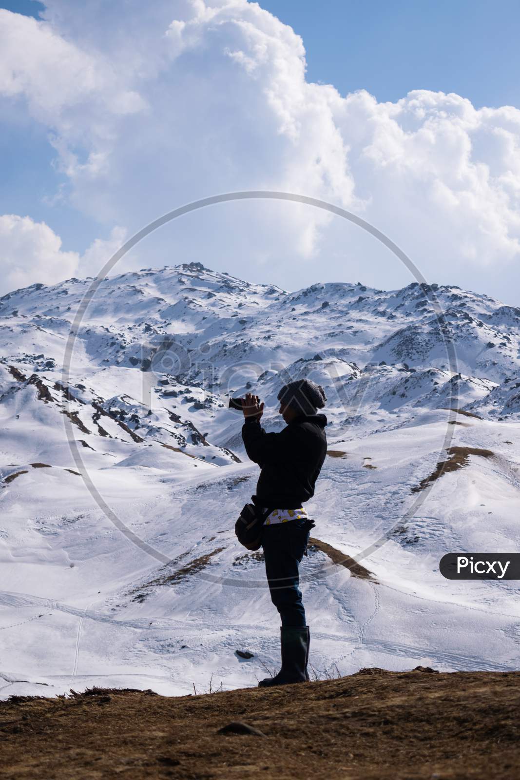 Person Photographing The Snow Covered Mountain Top