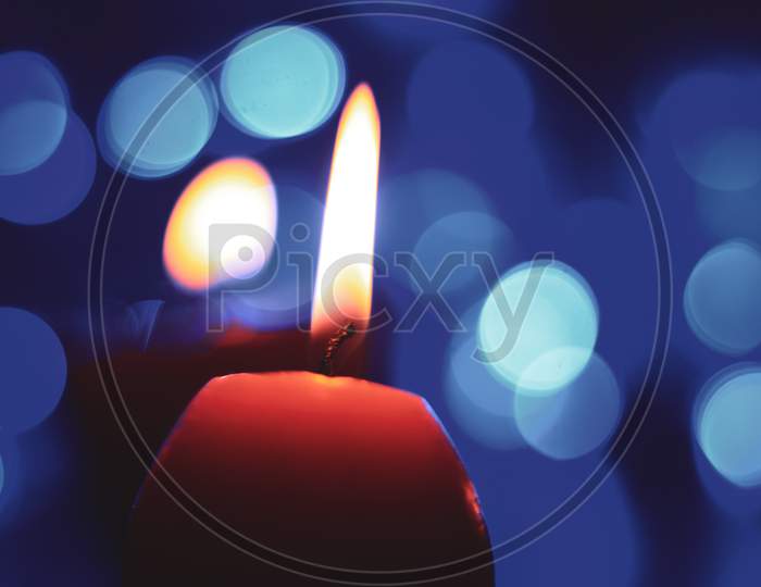Candle lights in darkness with colorful light effects and bokeh for solemn moments and wallpaper. Candle flame light at night with background.