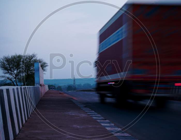 Blur Running Truck On Road With Zebra Pattern On Road Print Transporting Concept