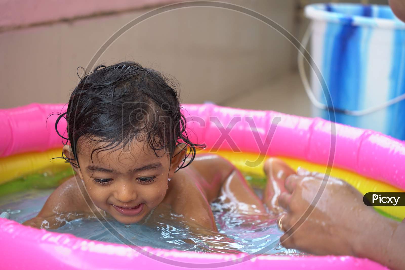 Indian Baby Boy Enjoying Bath In An Inflatable Pool