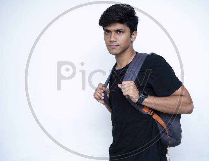 Young Indian Boy Wearing A Black Shirt Going To College, Captured On A White Background.