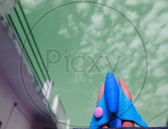 Blue Color Clay Space Craft On Turquoise Color Sky Behind The Object