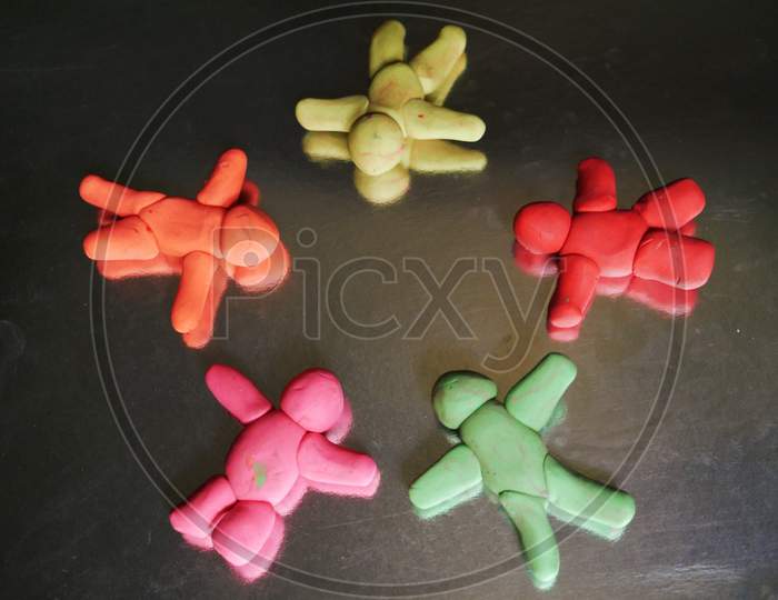 Cartoon Group Of People Lying On Circle Shape Made With Clay