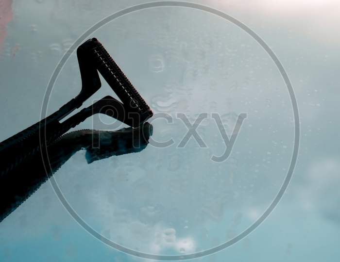 Shaving Razor Isolate On Glass Surface With Sky Reflection Text Space.