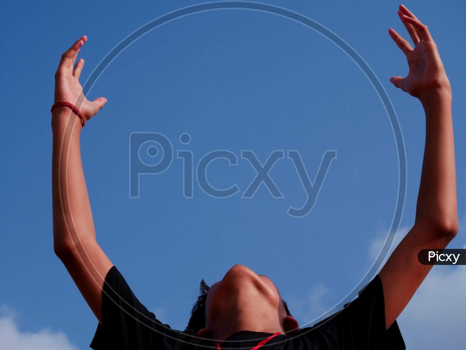 Boy Raising Hand With Happiness On Sky Backdrop.