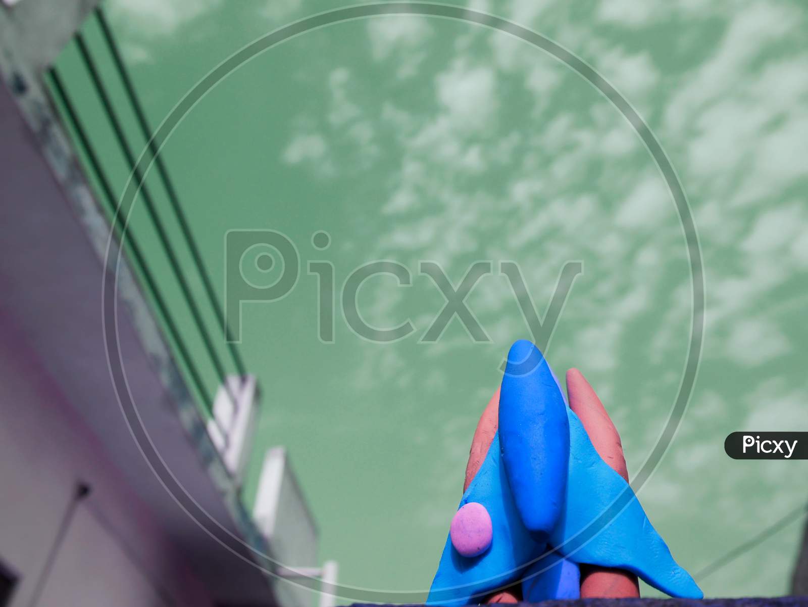 Blue Color Clay Space Craft On Turquoise Color Sky Behind The Object