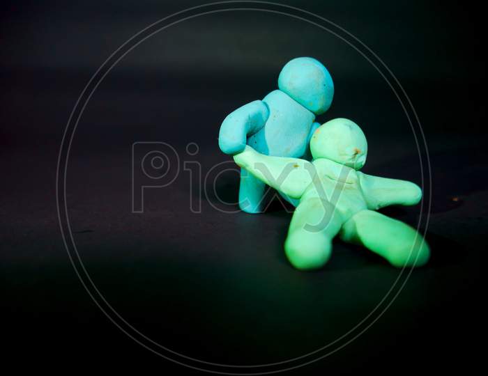 Two Clay Soft Toys Fighting On Black Background