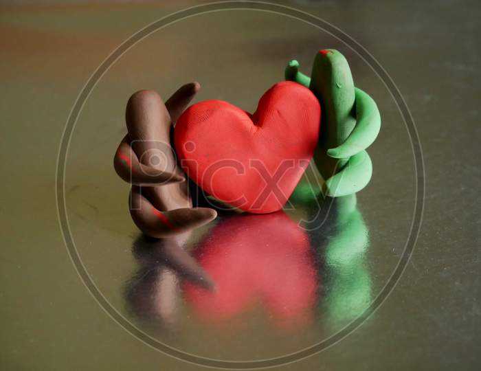 Two Clay Made Cartoon Couples Holding Hearts Together Presenting Love Each Others