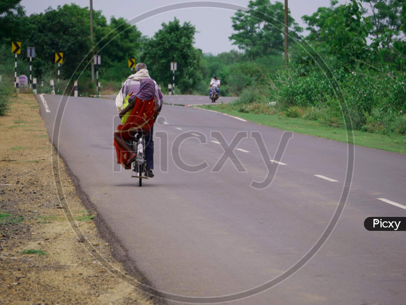 Indian Man And Woman Going Together On Road With Bicycle Transportation.