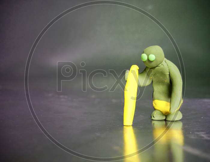 Clay Old Man Holding Yellow Stick Isolate On Silver Color Frame