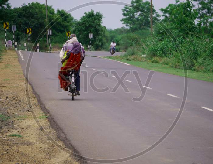 Indian Man And Woman Going Together On Road With Bicycle Transportation.