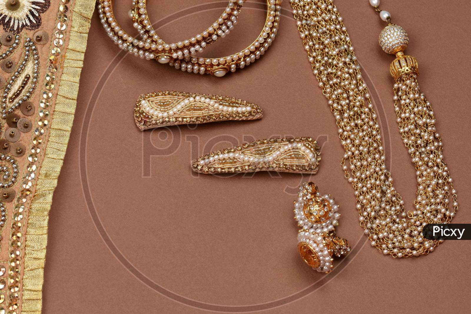 Pearl Jewelry On A Brown Background, Golden Scarf, Pearl Bracelet, Pearl Hair Clip, Pearl Necklace, Pearl Earringsjewelry Background.Style, Fashion And Design Of Jewelry. Indian Traditional Jewellery