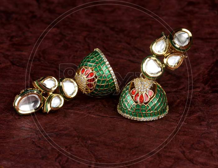 Beautiful Golden Pair Of Earrings Diamonds Gemstones On Textued Background. Luxury Female Jewelry, Indian Traditional Jewellery, Kundan Earring,Bridal Gold Earrings Wedding Jewellery