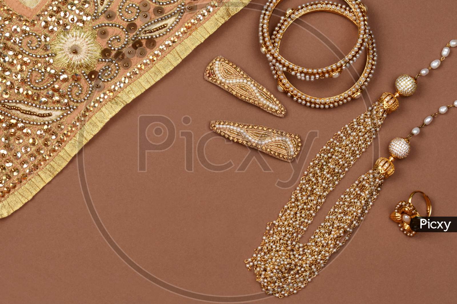 Pearl Jewelry On A Brown Background, Golden Scarf, Pearl Bracelet, Pearl Hair Clip, Pearl Necklacejewelry Background, Finger Ring.Style, Fashion And Design Of Jewelry. Indian Traditional Jewellery
