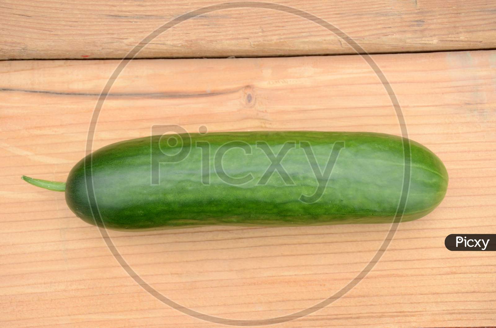 Closeup Ripe Green Cucumber On The Wooden Background.