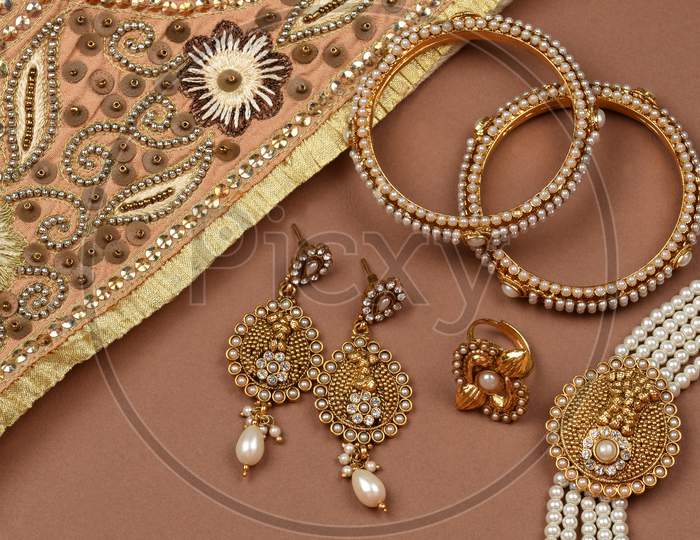 Pearl Jewelry On A Brown Background, Golden Scarf, Pearl Bracelet Jewelry Background, Pearl Necklace, Pearl Earrings, Finger Ring.Style, Fashion And Design Of Jewelry. Indian Traditional Jewellery