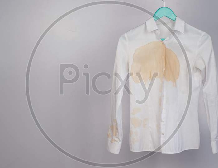 Women's office white shirt with a stain of coffee on a white background