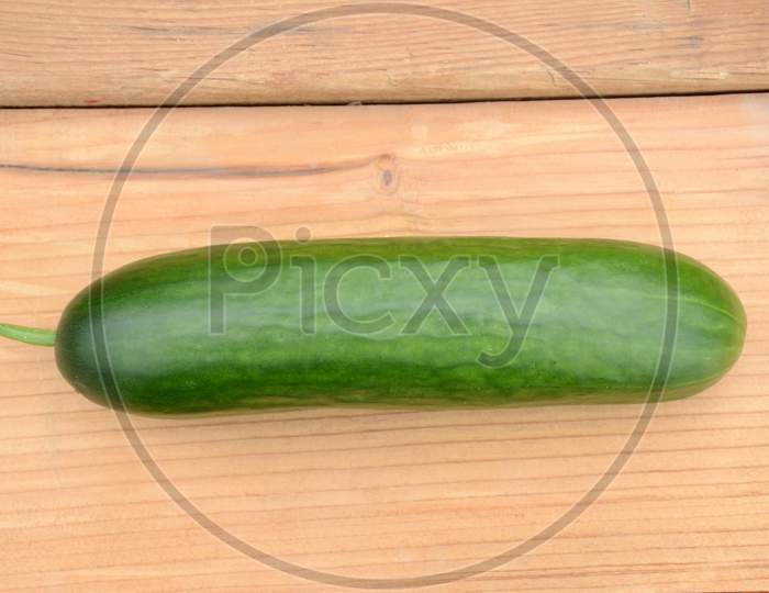Closeup Ripe Green Cucumber On The Wooden Background.