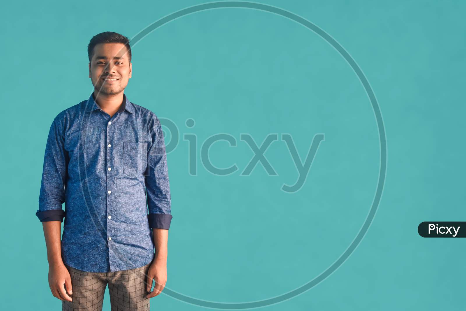 Young Indian businessman with a happy and cool smile on his face in semi-formal getup standing over isolated Green background Lucky person. Indian Business concept.