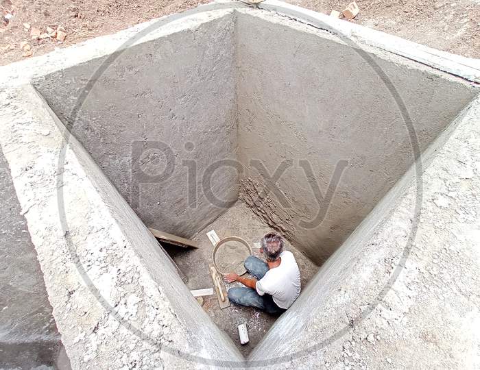 Skilled labour making septic tank.